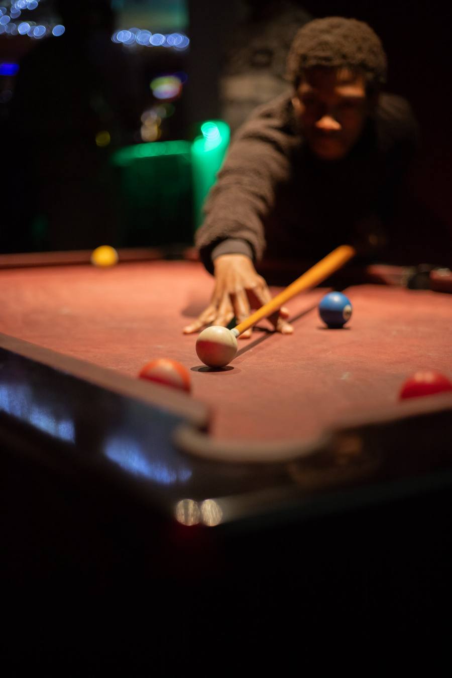 Man leaning over pool table with cue stick and balls