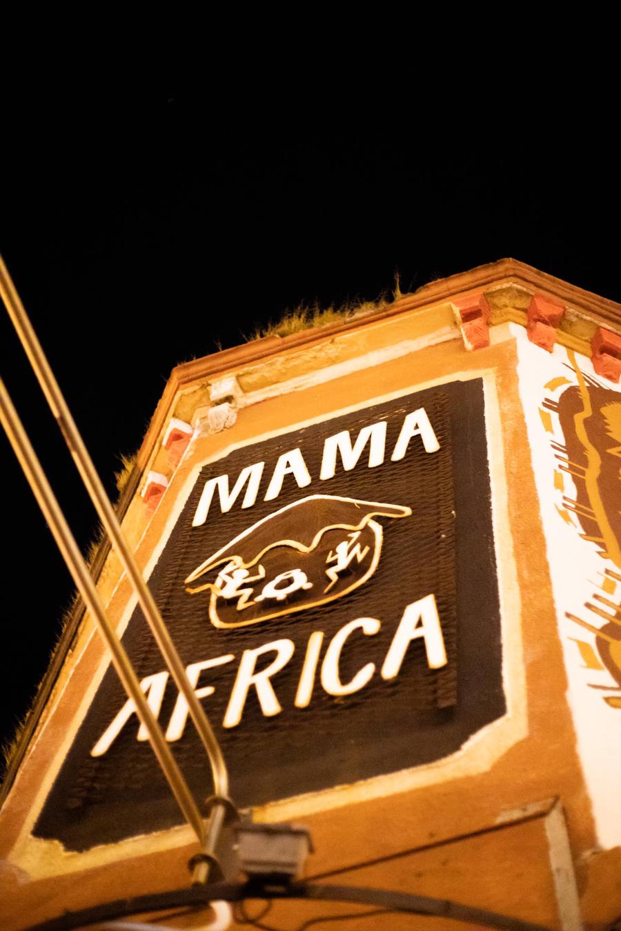 A sign for Mama Africa with a golden horned animal logo