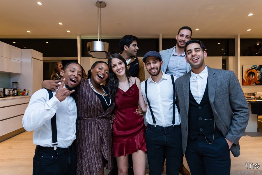 A group of friends smiling and posing for a photograph in a modern kitchen