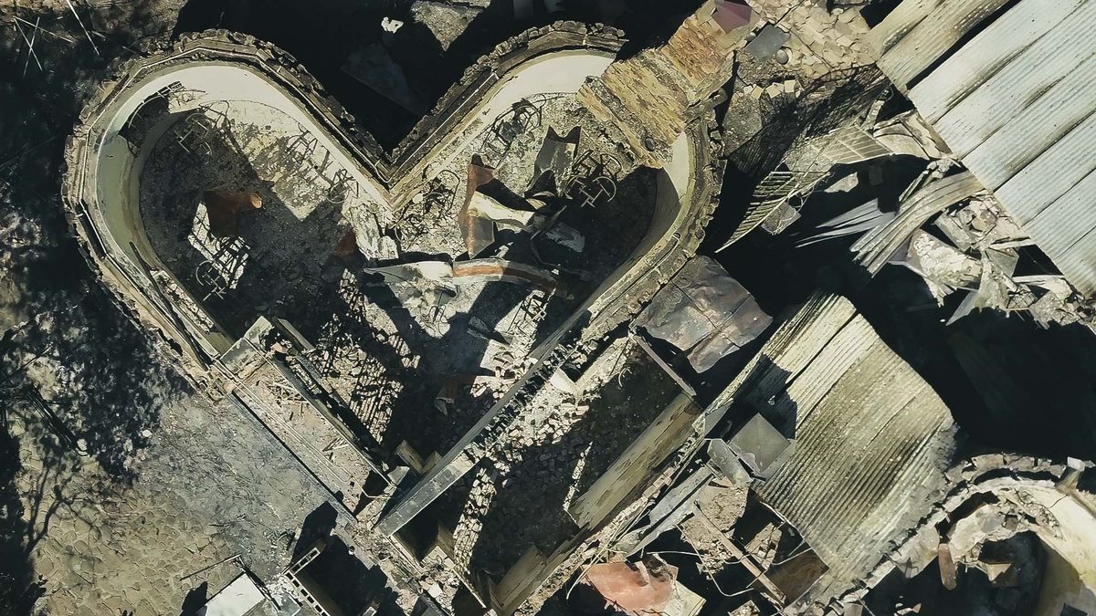 Aerial view of Rhodes Memorial ruins after a fire, showing charred remains and debris.