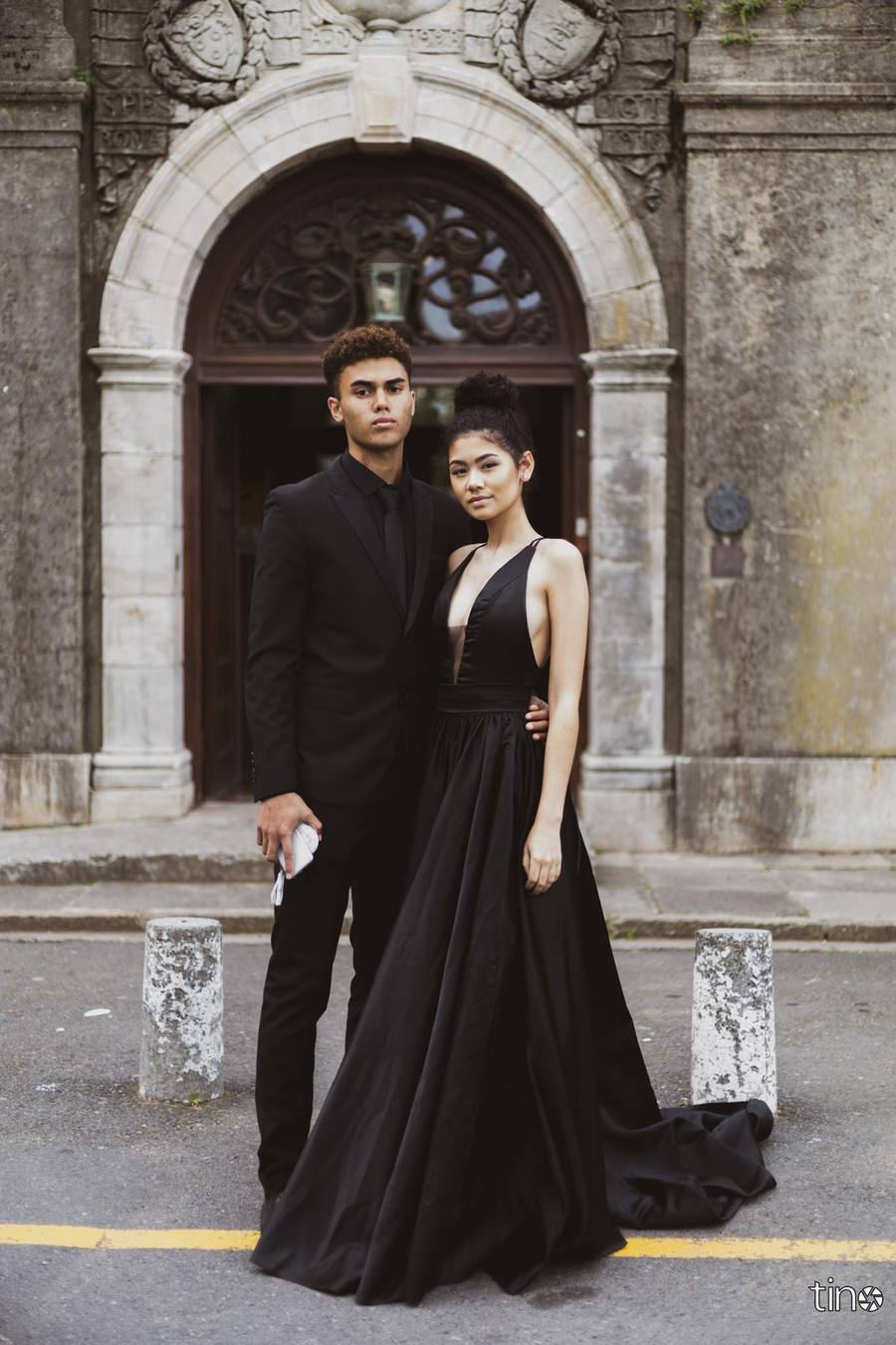 Couple in black attire standing in front of an ornate building